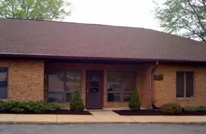 A brown brick building with trees in front of it.